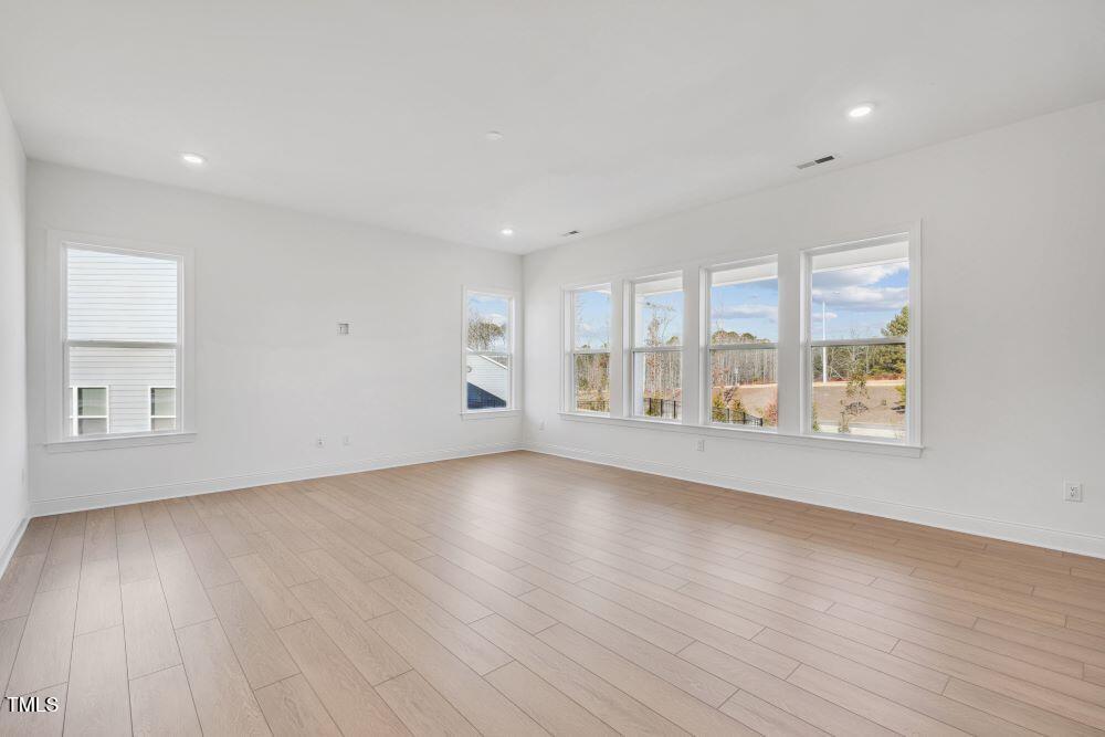 200 Regency Rdg Drive Apex, NC 27539 - Photo 5 of 39 an empty room with wooden floor and windows