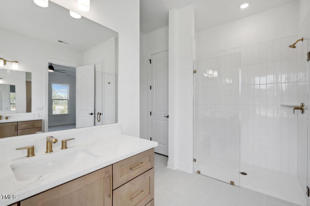 200 Regency Rdg Drive Apex, NC 27539 - Photo 8 of 39 a bathroom with a sink vanity granite tub and shower