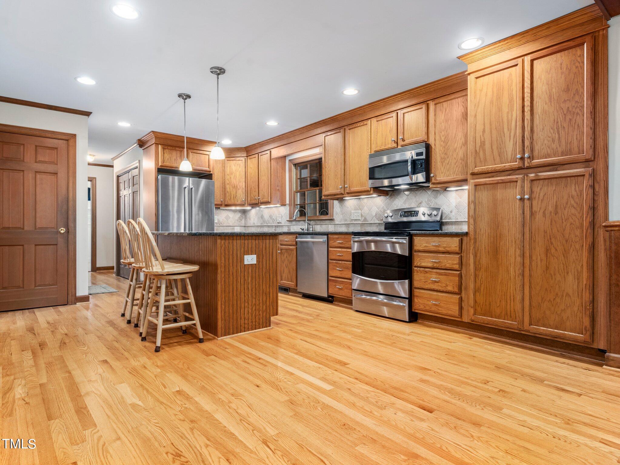 4205 Weaver Drive Raleigh, NC 27612 - Photo 14 of 48 a kitchen with stainless steel appliances granite countertop a refrigerator and a stove top oven