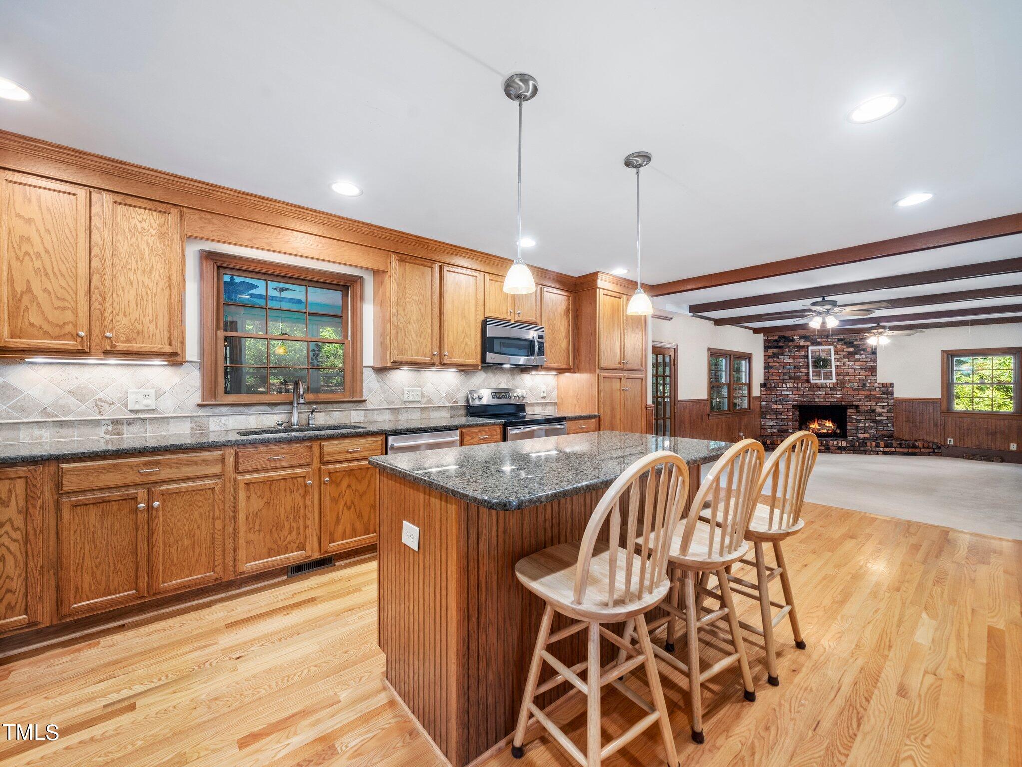 4205 Weaver Drive Raleigh, NC 27612 - Photo 16 of 48 a kitchen with stainless steel appliances granite countertop a stove a sink and a wooden cabinets