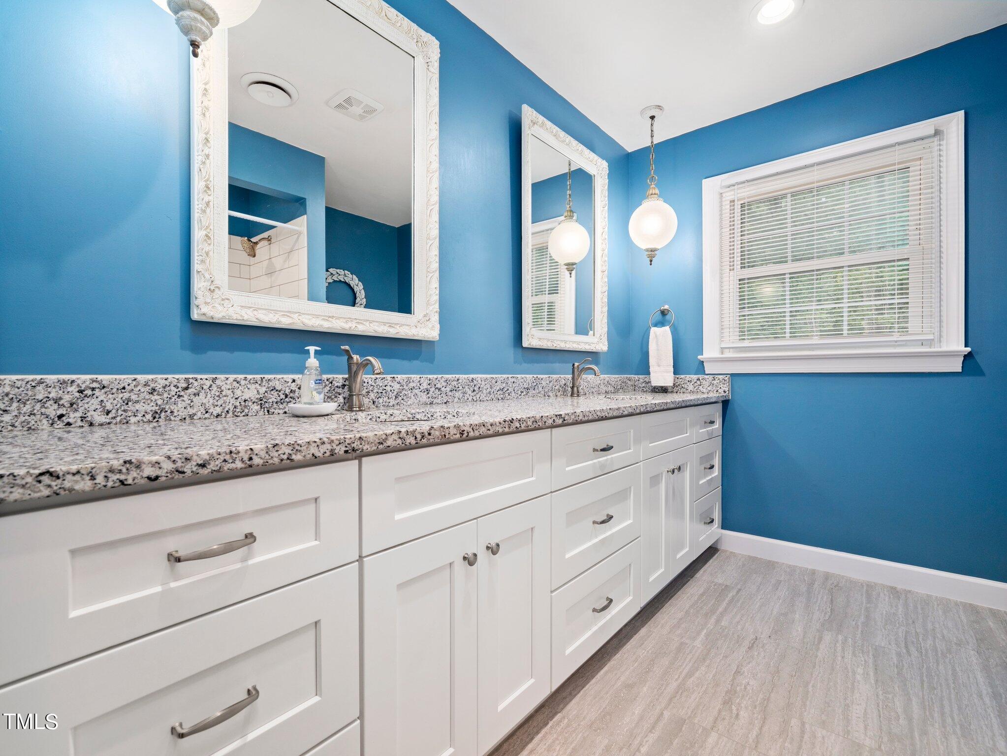 4205 Weaver Drive Raleigh, NC 27612 - Photo 28 of 48 a bathroom with a granite countertop double vanity sink and mirror