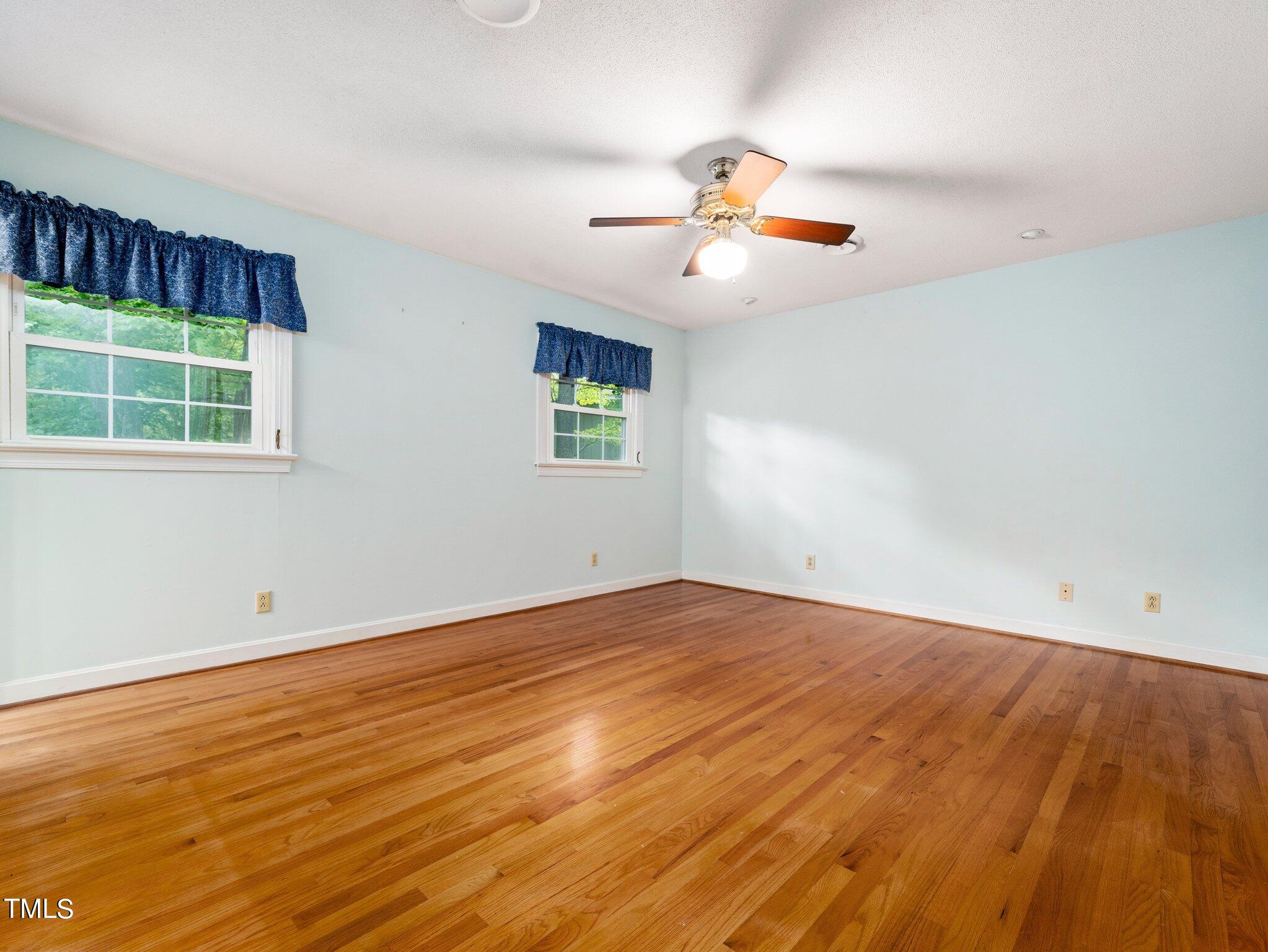 4205 Weaver Drive Raleigh, NC 27612 - Photo 30 of 48 an empty room with wooden floor fan and windows