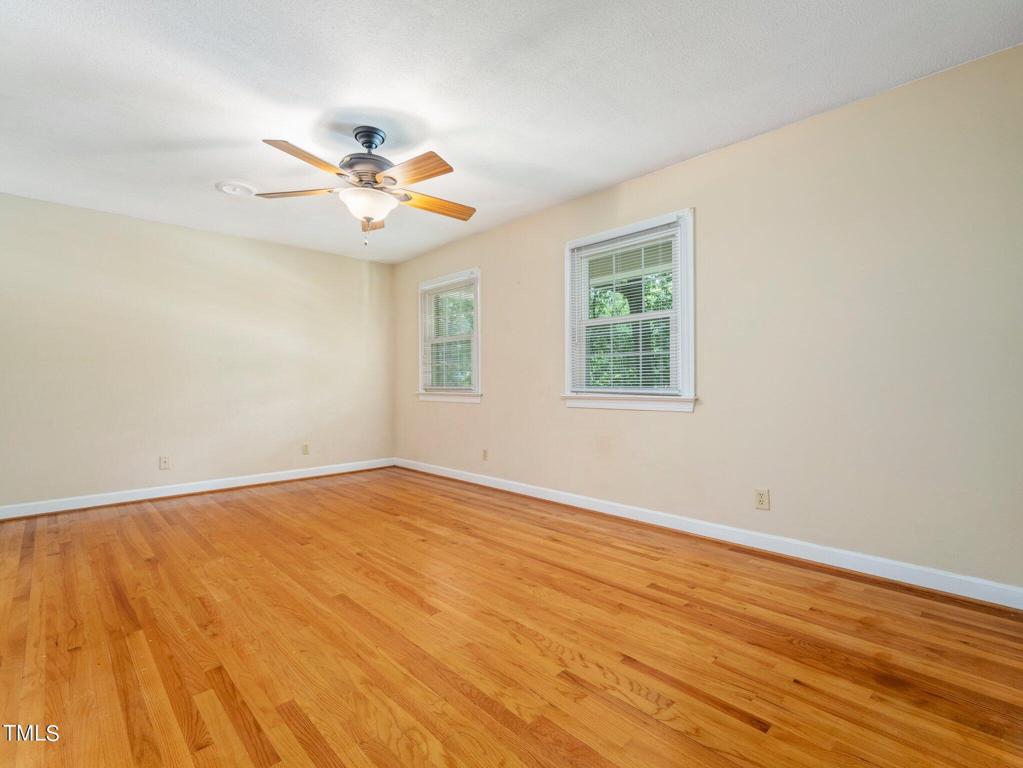 4205 Weaver Drive Raleigh, NC 27612 - Photo 32 of 48 an empty room with wooden floor fan and windows
