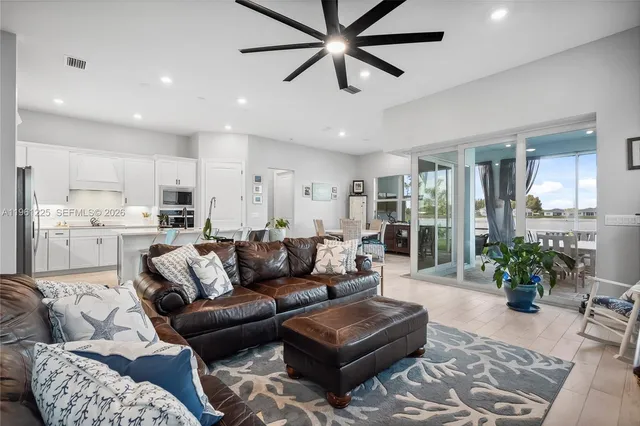 a living room with furniture and a view of kitchen