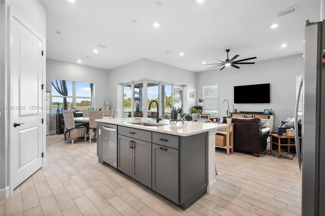 a large kitchen with kitchen island a sink a counter space and stainless steel appliances