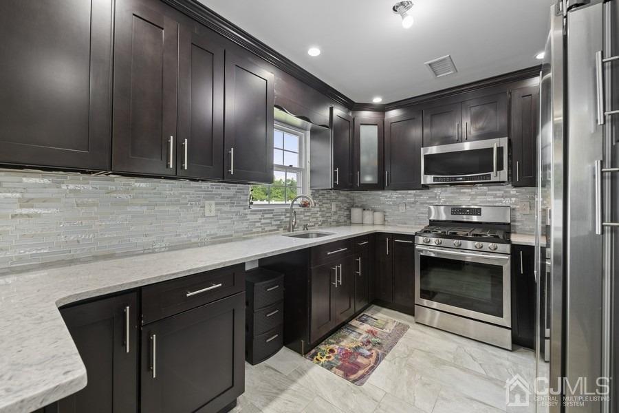 89 Normandy Drive Piscataway, NJ 08854 - Photo 13 of 20 a kitchen with stainless steel appliances kitchen island granite countertop a stove sink and cabinets