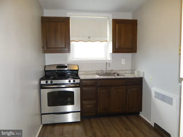 a bathroom with a sink a toilet a shower and a window