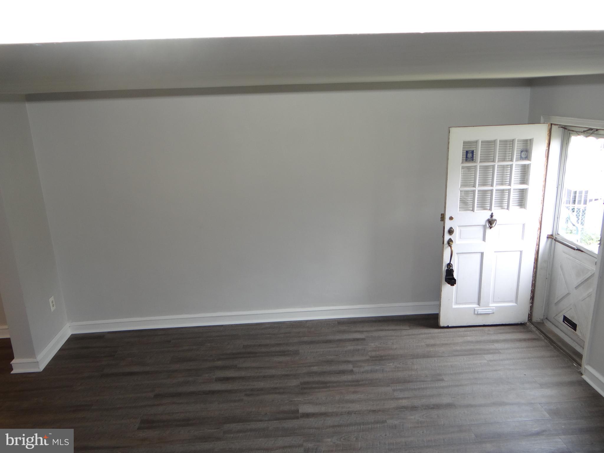 6744 Rutland Street Philadelphia, PA 19149 - Photo 6 of 44 a view of an empty room with wooden floor and a window