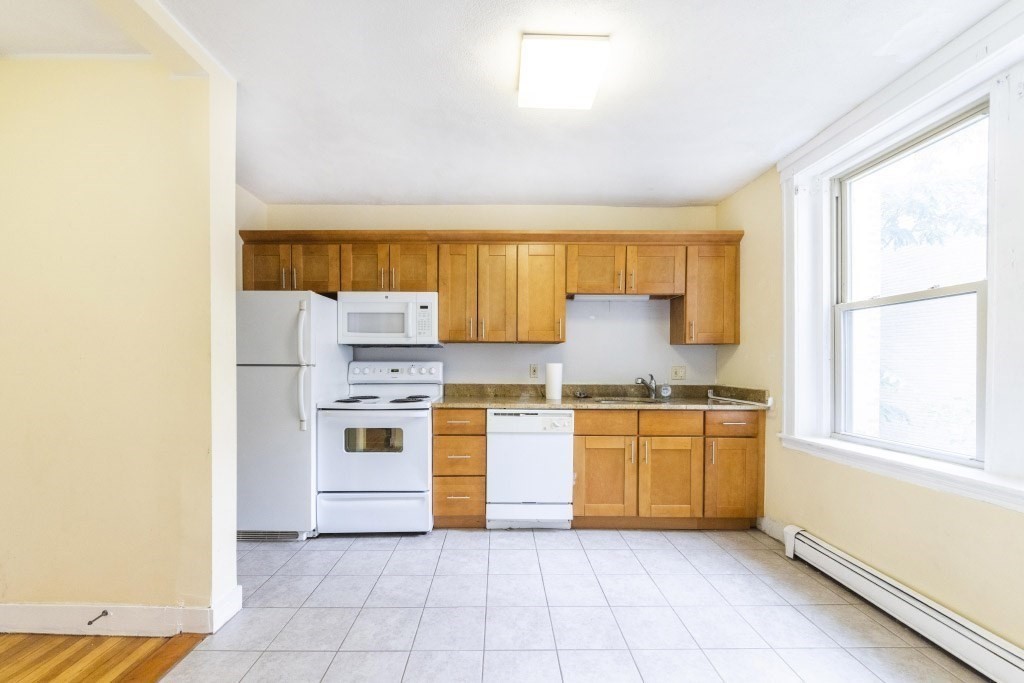 24 Ransom Road, Unit 8 Boston, MA 02135 - Photo 3 of 13 a kitchen with stainless steel appliances granite countertop a stove a sink and a refrigerator