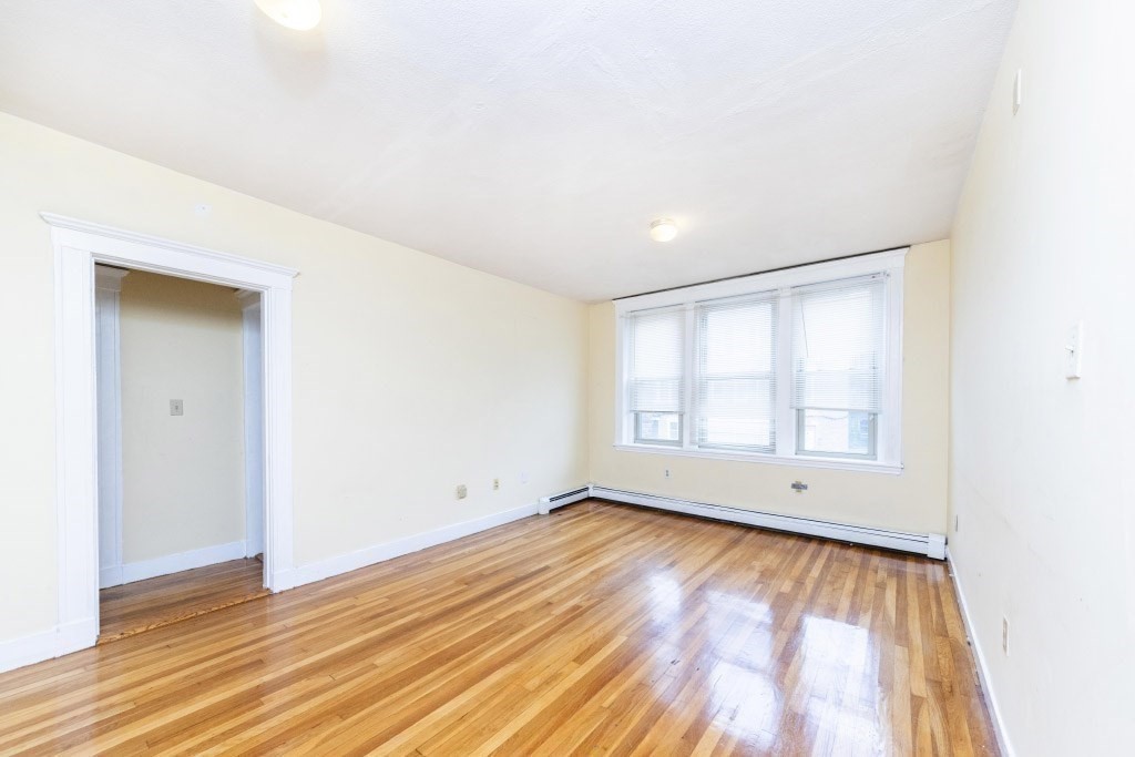 24 Ransom Road, Unit 8 Boston, MA 02135 - Photo 5 of 13 an empty room with wooden floor and windows