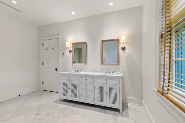 a spacious bathroom with double vanity and a mirror