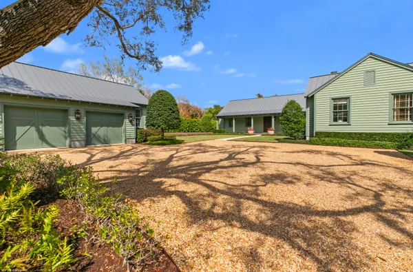 a front view of a house with a yard and potted plants