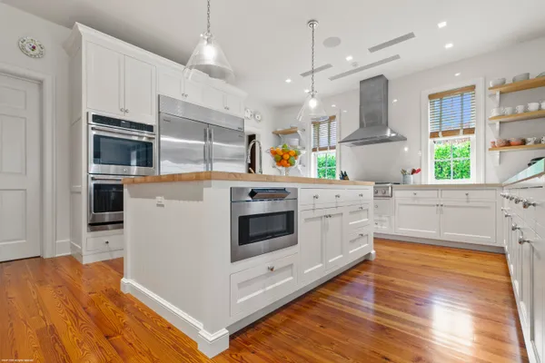 a kitchen with stainless steel appliances kitchen island granite countertop a stove a sink and a refrigerator