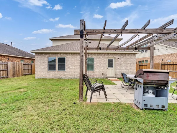 a backyard of a house with barbeque oven table and chairs