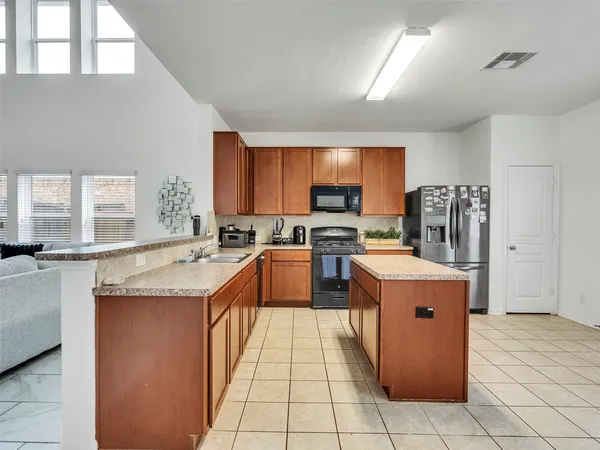 a large kitchen with stainless steel appliances granite countertop a stove a sink dishwasher and a refrigerator