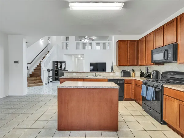 a kitchen with stainless steel appliances granite countertop a stove a sink dishwasher and a refrigerator