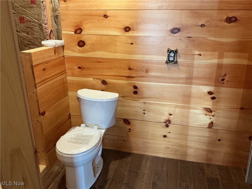 10550 Symmes Creek Road Adamsville, OH 43802 - Photo 15 of 21 Bathroom with dark wood finished floors and wooden walls