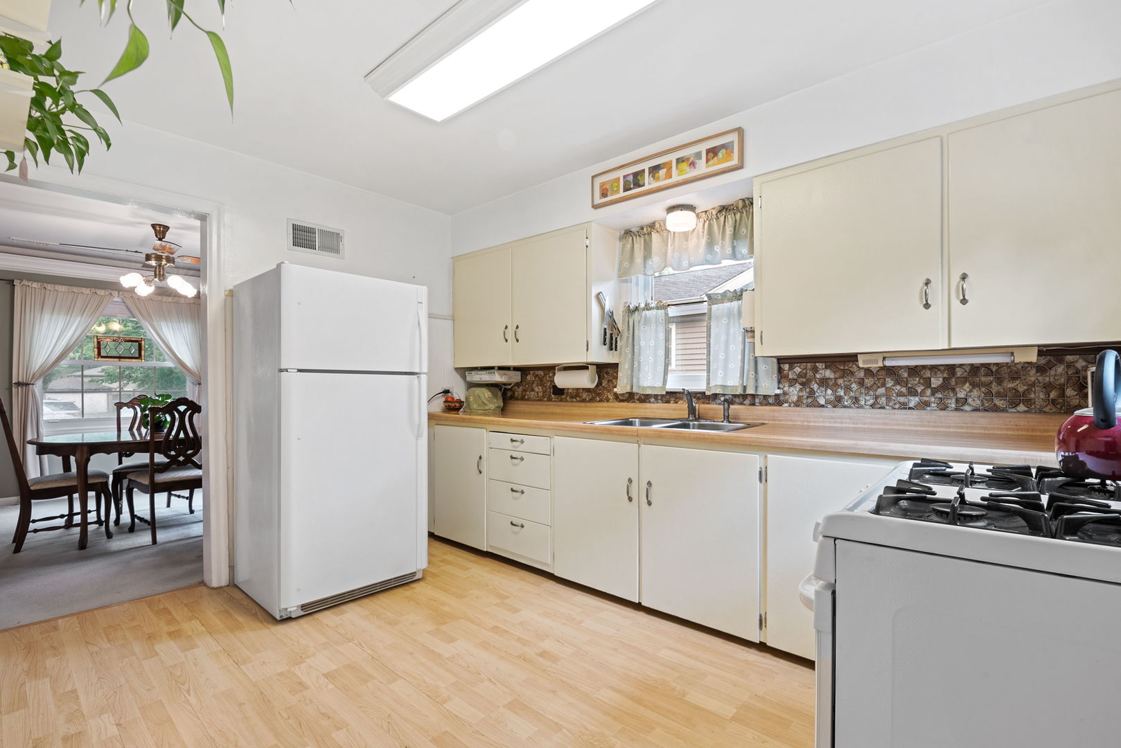 1656 Pine Road Homewood, IL 60430 - Photo 10 of 23 a kitchen with a refrigerator a stove a dining table and chairs