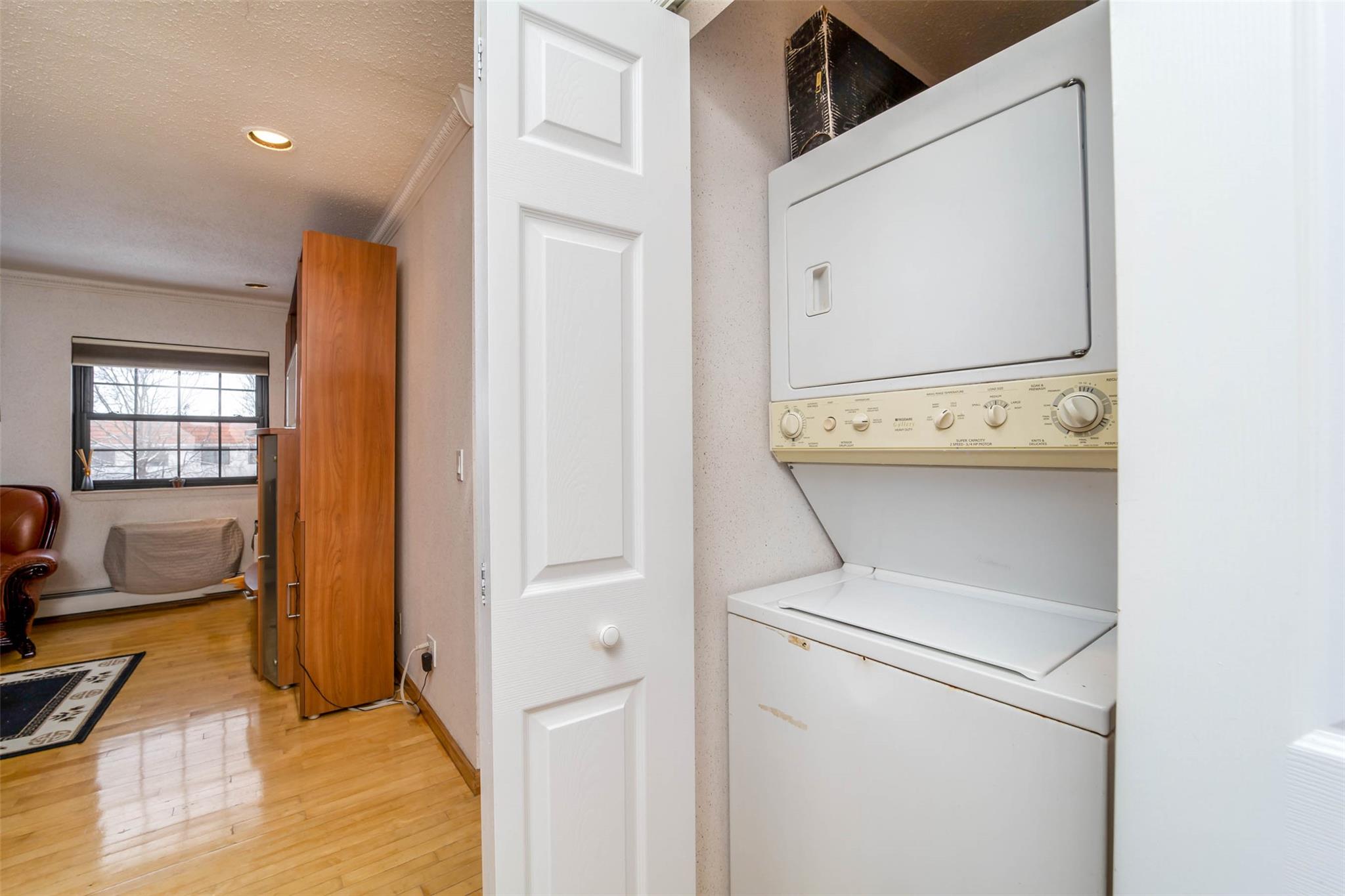 509 Julius Road Queens, NY 11356 - Photo 16 of 26 Washroom with stacked washer and clothes dryer, light wood-type flooring, ornamental molding, recessed lighting, and a textured ceiling