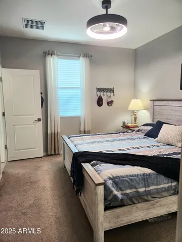 a spacious bedroom with a bed a couch and a chandelier