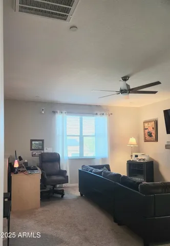 a bedroom with a bed a flat screen tv and guitar