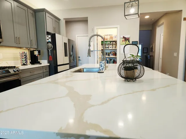 a kitchen with a sink refrigerator and cabinets