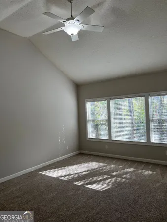 an empty room with a window and a ceiling fan