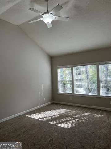 an empty room with a window and a ceiling fan