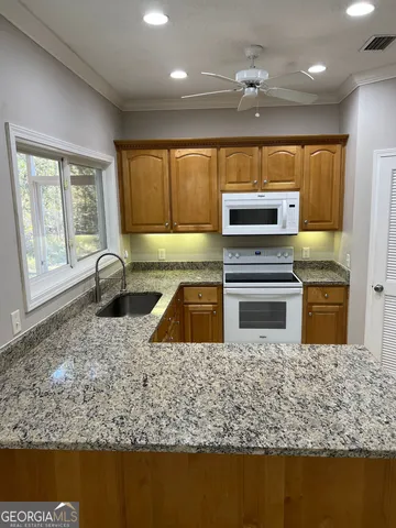 a kitchen with granite countertop a stove and a sink