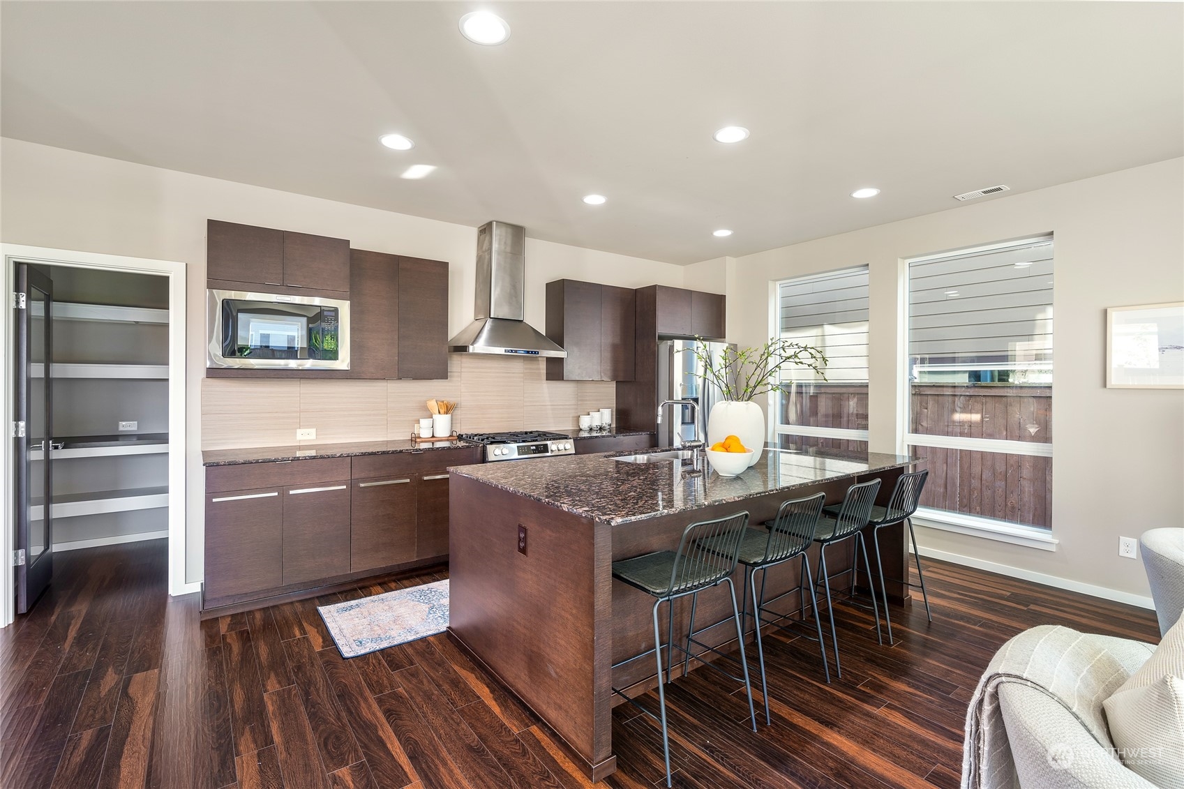 3926 171st Place Southeast Bothell, WA 98012 - Photo 11 of 40 a kitchen with stainless steel appliances granite countertop a stove top oven a sink dishwasher a dining table and chairs with wooden floor