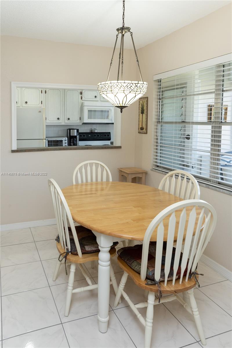 5300 Washington Street, Unit A234 Hollywood, FL 33021 - Photo 11 of 42 a dining table chair sitting in a kitchen