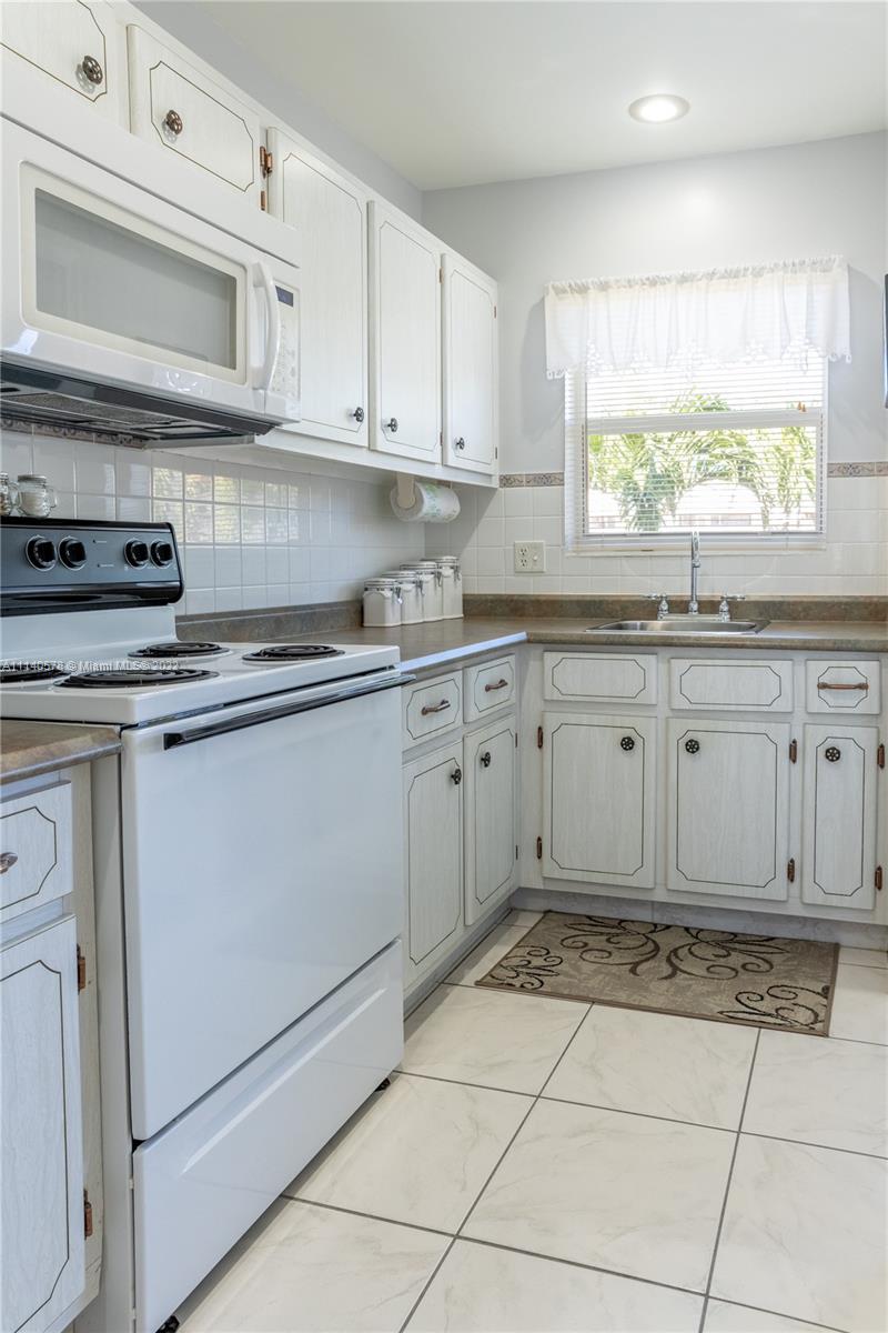 5300 Washington Street, Unit A234 Hollywood, FL 33021 - Photo 13 of 42 a kitchen with cabinets appliances and a window