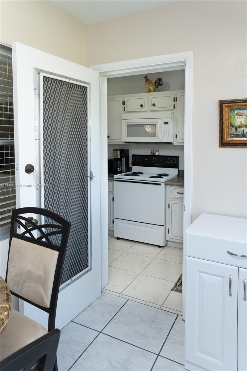 5300 Washington Street, Unit A234 Hollywood, FL 33021 - Photo 17 of 42 a kitchen with white cabinets and appliances