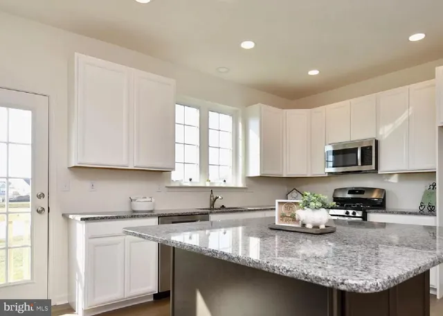 a kitchen with stainless steel appliances granite countertop a sink a stove and cabinets