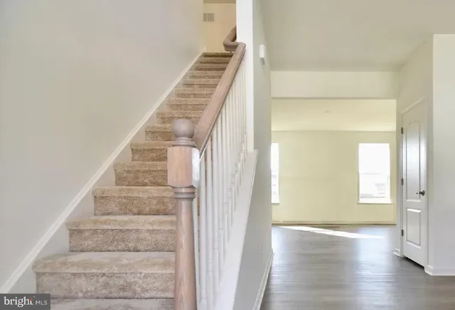 a view of an entryway with wooden floor and stairs