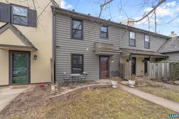 a view of a house with large windows and wooden fence