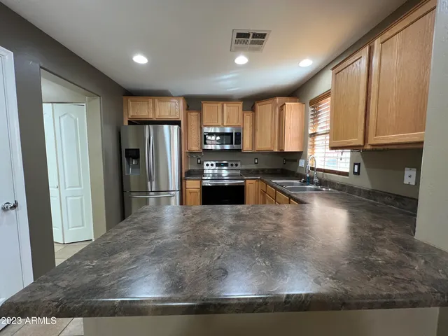 a kitchen with stainless steel appliances granite countertop a refrigerator a stove top oven a sink and dishwasher