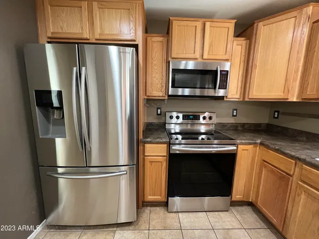 a kitchen with stainless steel appliances granite countertop a refrigerator stove a sink and a microwave