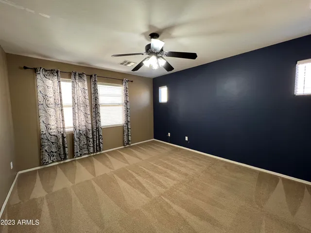 en empty room with windows and ceiling fan