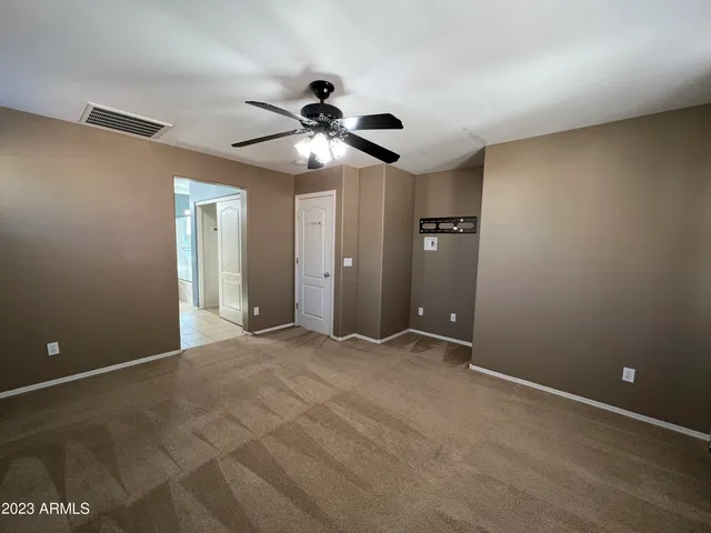 an empty room and chandelier fan