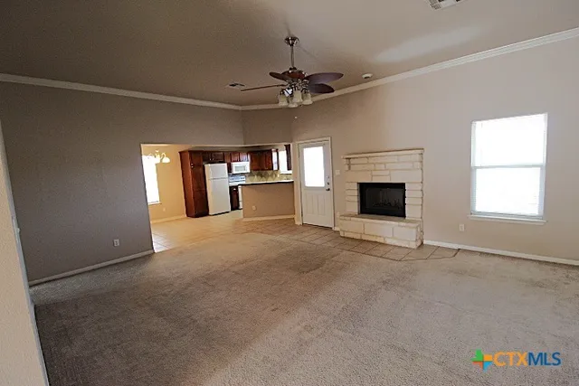 an empty room with fireplace and windows