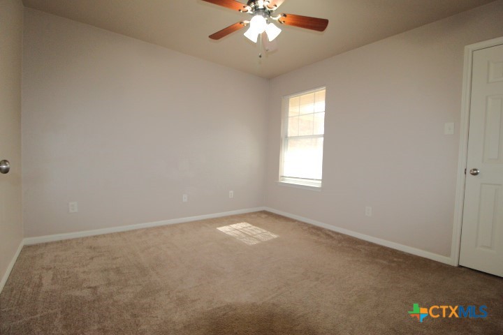 1804 Walker Pl Boulevard Copperas Cove, TX 76522 - Photo 9 of 12 an empty room with windows and chandelier fan