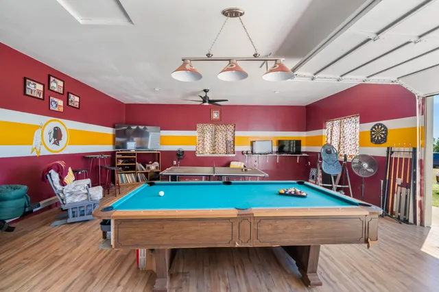 a view of a backyard with table and chairs under an umbrella with wooden fence