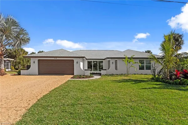 a front view of a house with a garden and yard