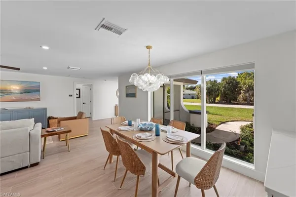 a dining room with furniture a chandelier and wooden floor