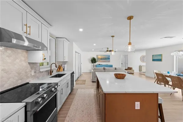 a kitchen with stainless steel appliances granite countertop a sink stove and refrigerator