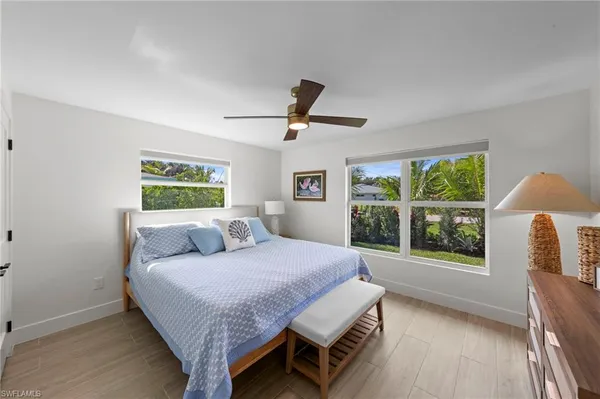 a bedroom with a bed and a large window