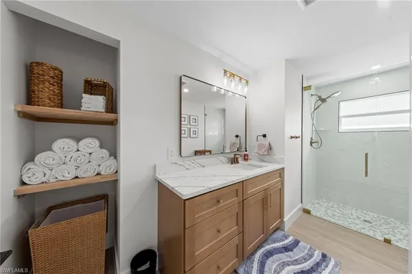 a spacious bathroom with a sink a mirror and a shower