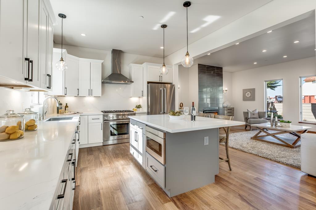 61 Elder Lane Pacifica, CA 94044 - Photo 8 of 37 a large kitchen with stainless steel appliances kitchen island granite countertop a lot of counter space and wooden floors