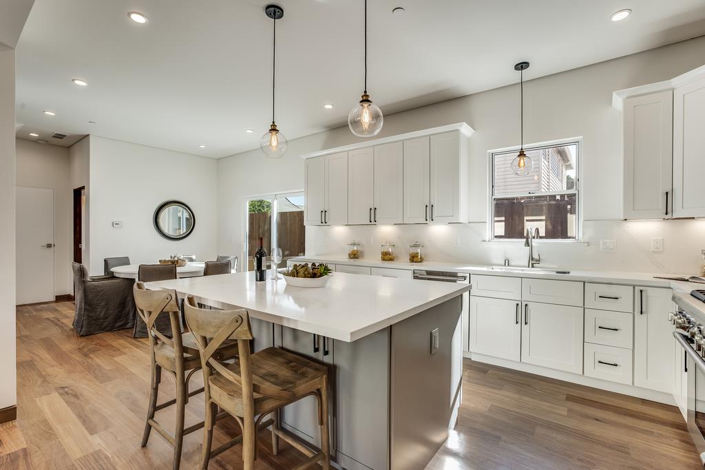 61 Elder Lane Pacifica, CA 94044 - Photo 9 of 37 a kitchen with stainless steel appliances granite countertop a sink a stove a dining table and chairs